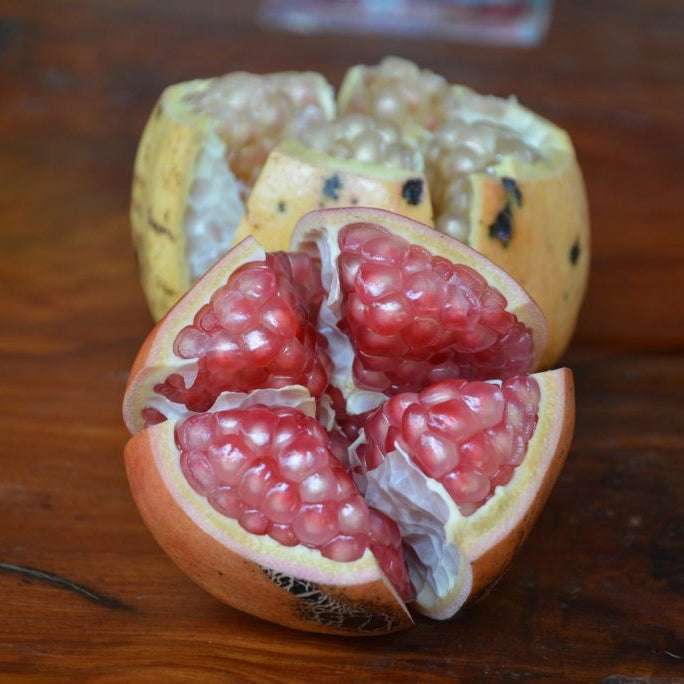 Pomegranate cut open on a wooden surface