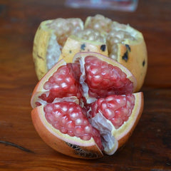 Pomegranate cut open on a wooden surface