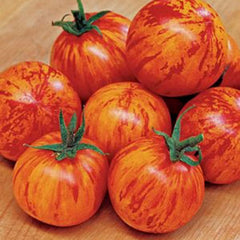 Marbled red and orange tomatoes on a wooden surface